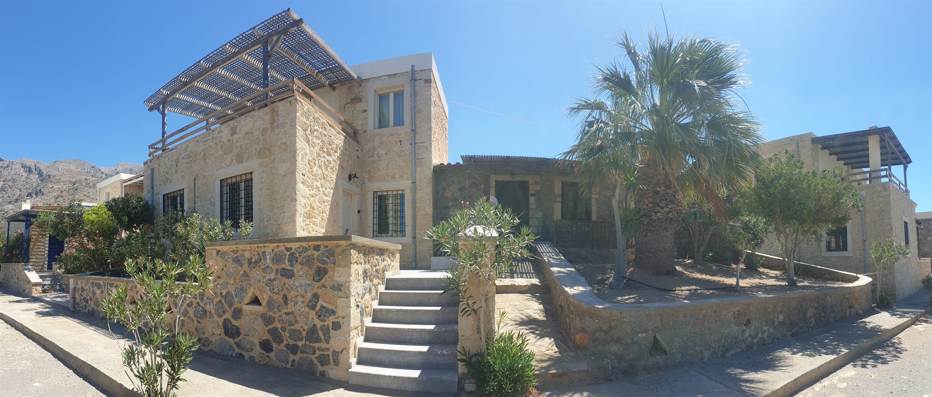 Stone-built Cavo Ponta accommodation and garden beside the rocky South Cretan coast